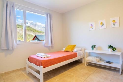 um pequeno quarto com uma cama e uma janela em Alojamiento Amor Amarillo em El Bolsón