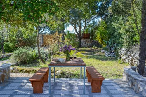 a picnic table with two benches and flowers on it at Green Oak Villa in Orthoniaí