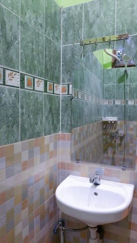 La salle de bains est pourvue d'un lavabo et d'un miroir. dans l'établissement Sleepy Raccoon Hostel, à Yogyakarta