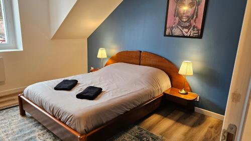 een slaapkamer met een bed met twee zwarte handdoeken erop bij Logements neufs à Bannalec Centre in Bannalec