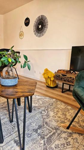 a living room with a table and a tv at Logements neufs à Bannalec Centre in Bannalec