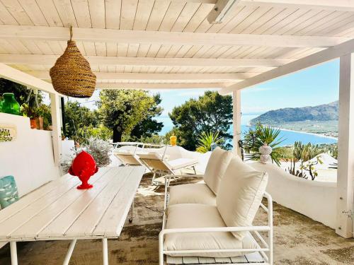 un patio con mesa y sillas y vistas al océano en Casa Molo 13 en Mattinata