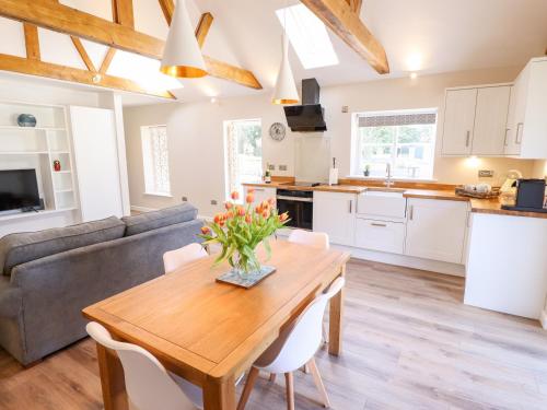 a kitchen and living room with a table and a couch at The Asparagus Shed in Sleaford