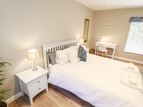 a bedroom with a white bed and a window at The Asparagus Shed in Sleaford