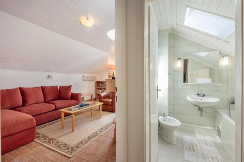 a living room with a red couch and a sink at Detached Villa with stunning views in Njivice, Montenegro in Njivice