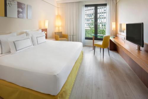 a hotel room with a large bed and a tv at Melia Luxembourg in Luxembourg