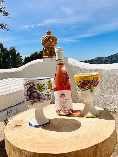 a bottle of wine and two wine glasses on a table at Casa Molo 13 in Mattinata