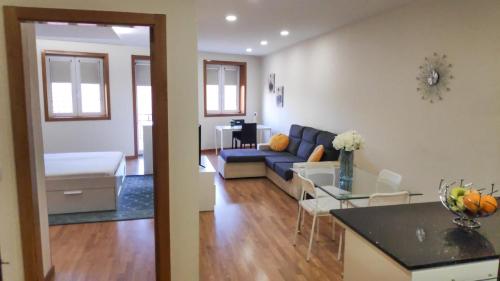 ein Wohnzimmer und eine Küche mit einem Sofa und einem Tisch in der Unterkunft Porta 116 - Free Private Parking in Vila Real