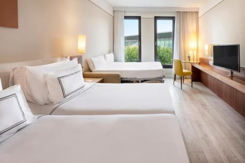 a hotel room with two beds and a television at Melia Luxembourg in Luxembourg