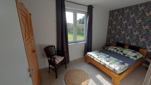 a bedroom with a bed and a window and a chair at Unterkunft Hugo-Steinfeld-Straße 1 Gebäude rechts in Uelzen