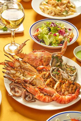 a table with a plate of seafood and a glass of wine at Daeha Serviced Apartment in Hanoi
