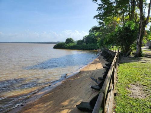 a beach with a fence next to a body of water at Hello-Guyane, Marina 5, Studio Prestige 5 étoiles in Saint-Laurent du Maroni