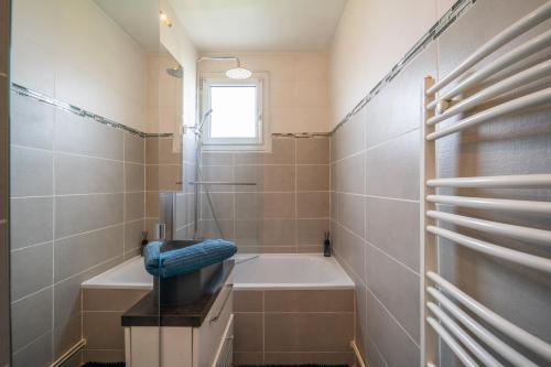 y baño con bañera, lavamanos y ducha. en Le Rosier - 20 min de Paris et d'Orly, en Vitry-sur-Seine