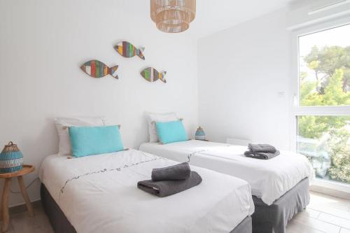 - 2 lits blancs dans une chambre avec fenêtre dans l'établissement Appartment Alizée, airco, pool and near beach, à La Croix-Valmer