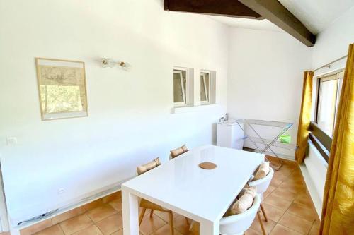 a white dining room with a white table and chairs at Appartement spacieux 65M2, avec piscine et parking in Fréjus
