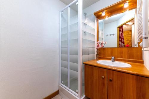 a bathroom with a sink and a glass shower at La Ferme des Alpages - Proche pistes de ski in La Giettaz