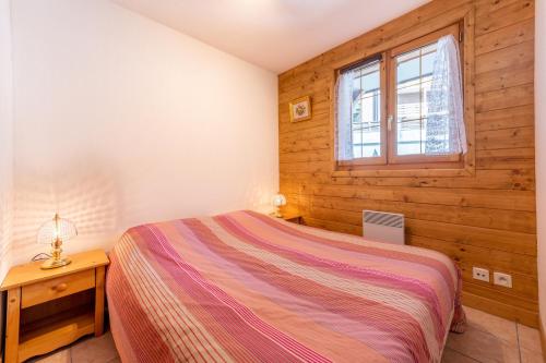 une chambre avec un lit et une fenêtre dans l'établissement La Ferme des Alpages - Proche pistes de ski, à La Giettaz