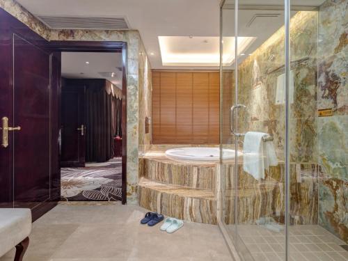 uma casa de banho com um chuveiro e uma banheira em Days Hotel & Suites China Town - Metro Line 2 - Nearby Wuyi Square ,Orange Island,Hunan Museum em Changsha