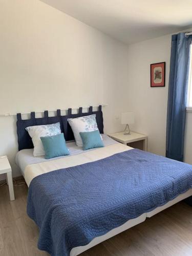a bedroom with a large bed with blue blankets and pillows at Gîte calme et cosy d' Eole in Cornillon-Confoux