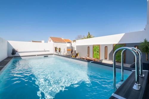 a swimming pool with blue water in a house at Don Jose Ocean View Heated Pool in Lagoa