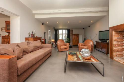sala de estar con sofá y mesa en Maison de charme - Piscine - Hypercentre - 300m2, en Lisle-sur-Tarn