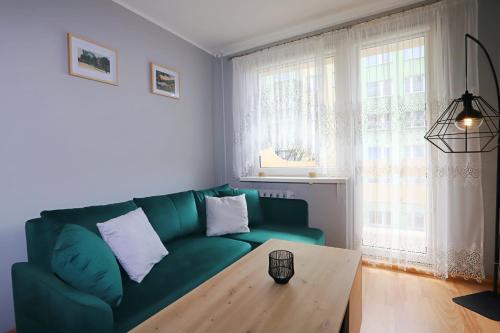 sala de estar con sofá verde y mesa en Apartament Zielony Dąb, en Wałbrzych