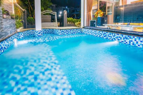 - une piscine avec du carrelage bleu et un lavabo dans l'établissement Villa FLC Sầm Sơn, à Sầm Sơn