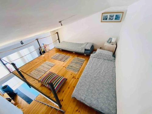 Habitación con cama y suelo de madera con alfombras. en Pet-friendly two-room family apartment in magical Bale, en Bale