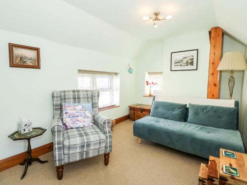 a living room with a couch and a chair at Beck Cottage in Sheringham