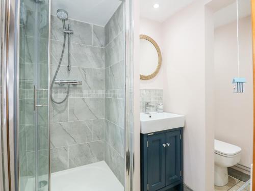 a bathroom with a shower and a sink and a toilet at Beck Cottage in Sheringham
