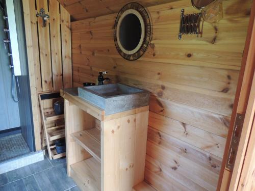 baño con lavabo en una pared de madera en CHALET ATYPIQUE LOLA type KOTA location en gîte, en Chazemais