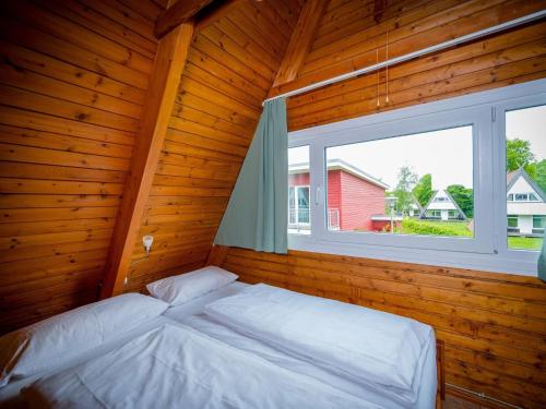 una camera da letto con un letto in una stanza con una finestra di Ferienhaus in Damp for 8 Personen a Damp