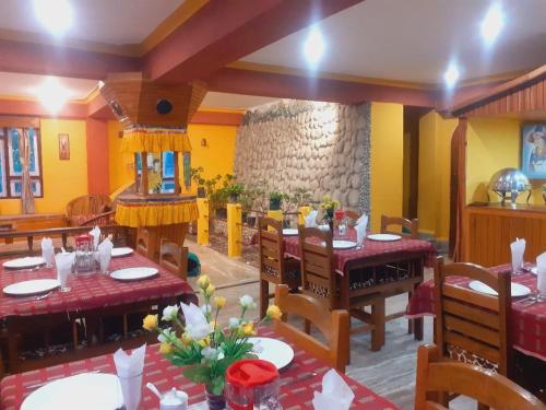 a restaurant with tables and chairs and a stone wall at Roys Rabdentse Residency in Pelling