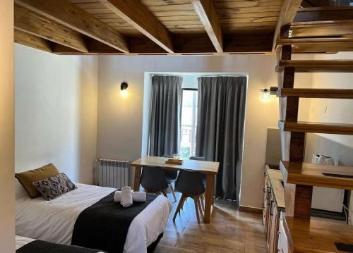 a bedroom with a bed and a desk and a table at NB Mountain aparts El Chalten in El Chalten