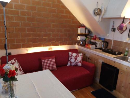 a living room with a red couch in a kitchen at appartamento " il piccolo ' in Rome