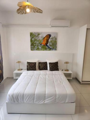 a bedroom with a bed with a bird on the wall at Hello-Guyane, Marina 6, Suite Prestige 5 étoiles in Saint-Laurent du Maroni