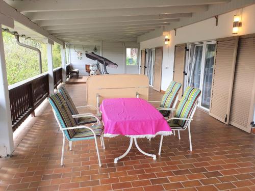 a table and chairs on a porch with a pink blanket on it at Apartment by Wörthersee with Pool in Karnten