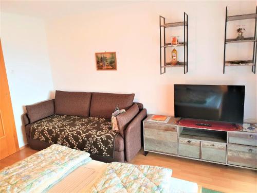 a living room with a couch and a flat screen tv at Apartment by Wörthersee with Pool in Karnten
