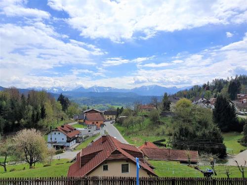 a village with a road and mountains in the background at Apartment by Wörthersee with Pool in Karnten