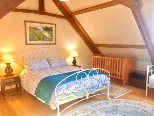 een slaapkamer met een wit bed op zolder bij Nice cottage in Sainte-Marguerite-d'Elle with garden in Sainte-Marguerite-dʼElle