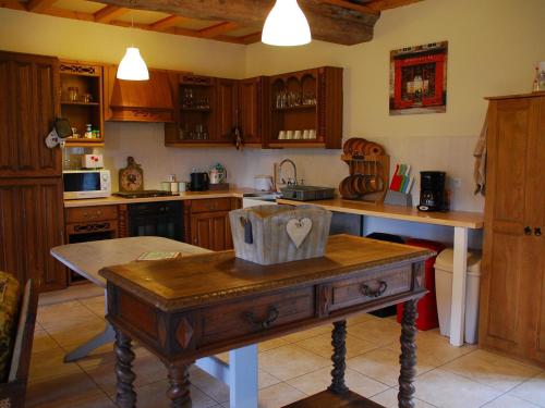 une cuisine avec une table au milieu dans l'établissement Cottage in Normandy near Château Balleroy, à Sainte-Marguerite-dʼElle