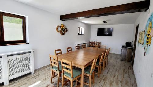 uma sala de jantar com uma mesa de madeira e cadeiras em Casa Albinuța em Călimăneşti