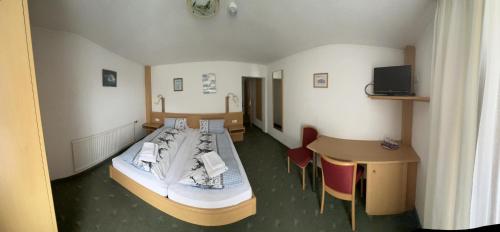 Zimmer mit einem Bett, einem Schreibtisch und einem Tisch in der Unterkunft Gasthof Schönblick Rußbach in Gseng