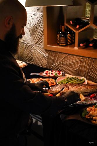 a man sitting at a table with several pizzas at Dim's Hotel & Restaurant in Korçë