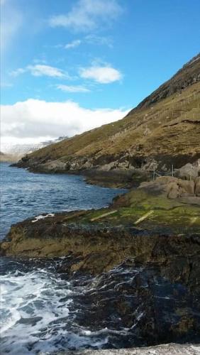 a view of a body of water with a hill at The Old Store in Hellur