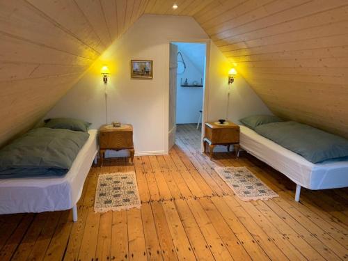 a attic room with two beds and two tables at The Old Store in Hellur