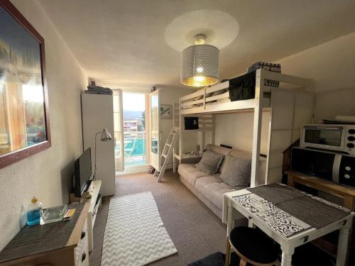 salon z kanapą i łóżkiem piętrowym w obiekcie Studio avec Clim, Parking et Balcon - 3 personnes w mieście Bormes-les-Mimosas