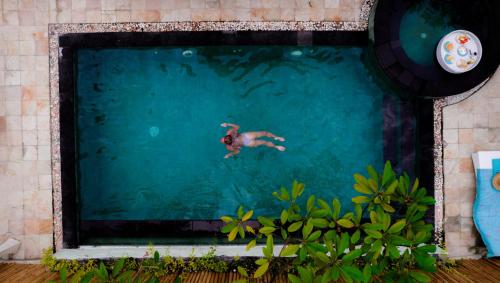 a man swimming in a swimming pool at VILLA MENORCA in Gili Trawangan