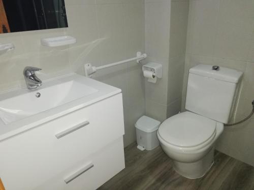 een badkamer met een wit toilet en een wastafel bij Mimosa LOCDENIA in Els Poblets