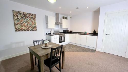 a kitchen with a wooden table and a table and chairs at Friars House, Stafford by BELL Apartments in Stafford